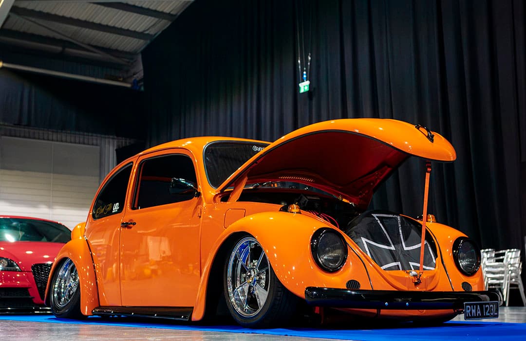 Orange 1970s VW Beetle featured at Ultimate Dubs UK 2024 with Air Lift Performance