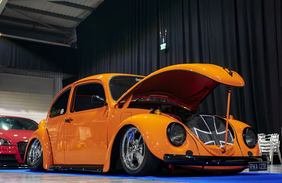 Orange 1970s VW Beetle featured at Ultimate Dubs UK 2024 with Air Lift Performance 